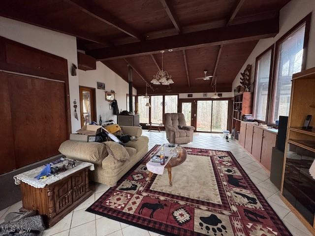 living room featuring vaulted ceiling with beams, light tile patterned floors, wood ceiling, and an inviting chandelier