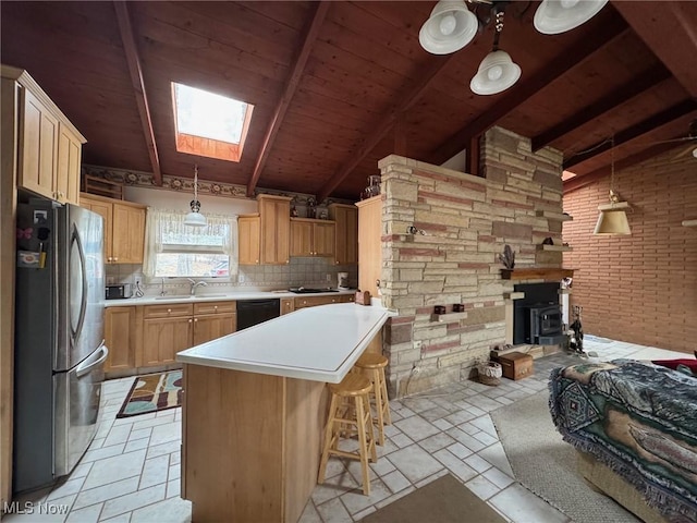 kitchen featuring pendant lighting, light countertops, freestanding refrigerator, a kitchen island, and dishwasher