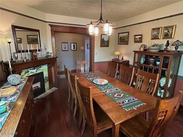 dining room with dark wood-type flooring, a fireplace, and a textured ceiling