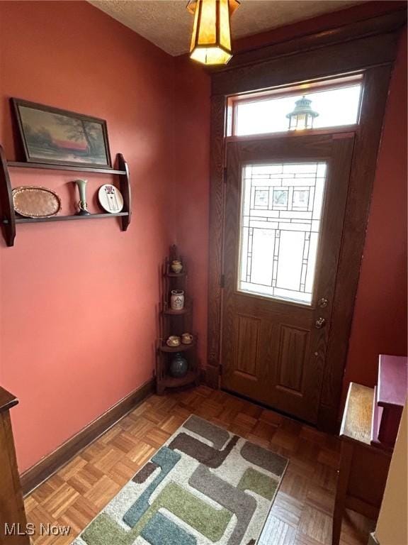 entrance foyer with a textured ceiling and baseboards