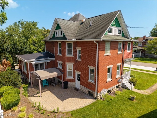 601 W 3rd St, Williamstown, WV 26187 - rear view of property with brick siding, a lawn, a patio area, and roof with shingles