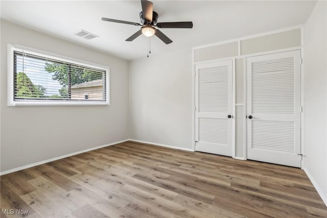 unfurnished bedroom with a closet, baseboards, and wood finished floors