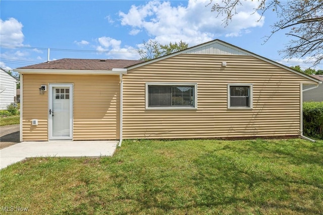 back of house with a patio area and a lawn