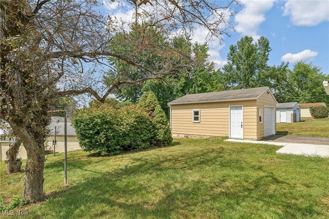 view of yard featuring a garage and an outdoor structure