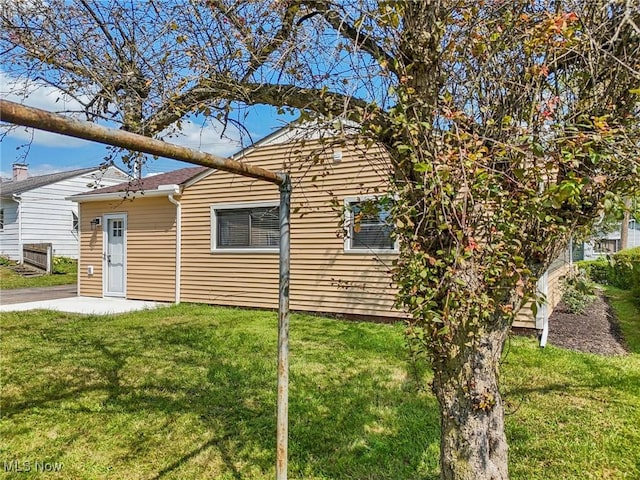 view of side of property with a patio area and a yard