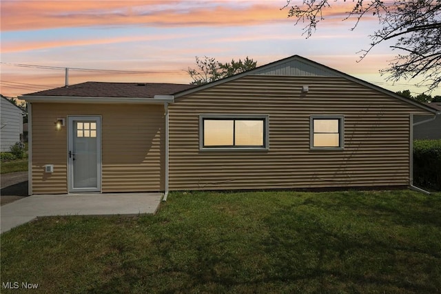 back of house with a patio and a lawn