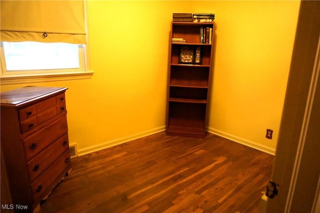 unfurnished bedroom featuring visible vents, baseboards, and dark wood-style flooring