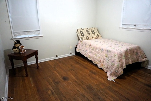 bedroom featuring dark wood finished floors and baseboards