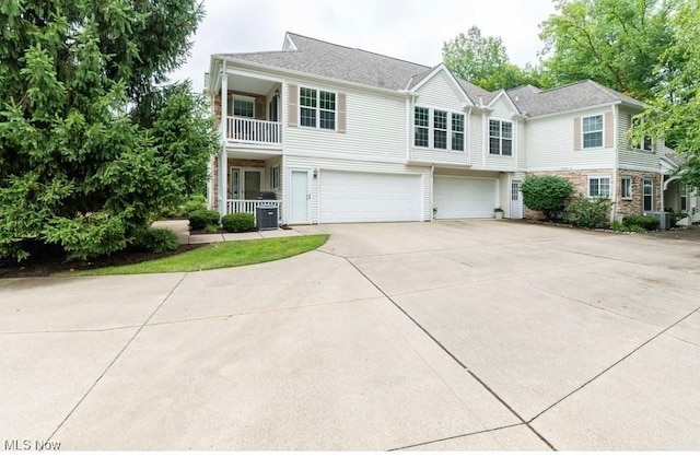 view of front of property with a garage, central AC, and concrete driveway