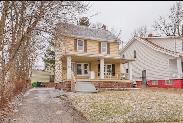 traditional style home with covered porch and a chimney