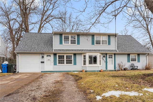 traditional-style home with a garage, roof with shingles, and driveway