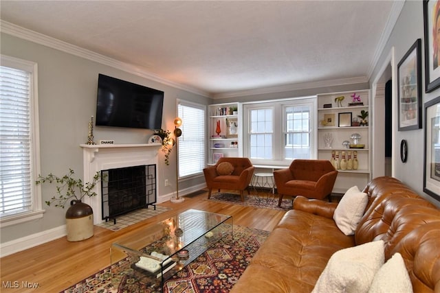 living room with a fireplace with flush hearth, a healthy amount of sunlight, ornamental molding, and wood finished floors