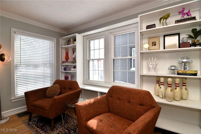 sitting room with visible vents, crown molding, baseboards, and wood finished floors