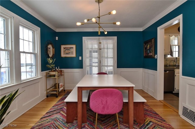 dining room featuring a chandelier, wainscoting, and light wood-style flooring