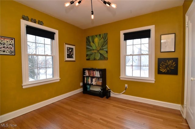 unfurnished room with light wood-type flooring, a wealth of natural light, and baseboards