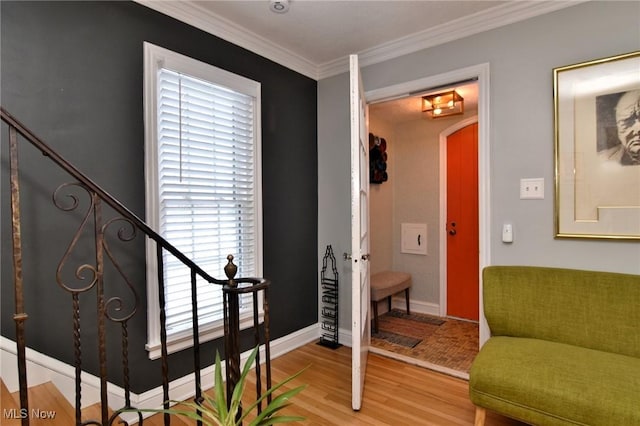 living area featuring arched walkways, stairway, ornamental molding, wood finished floors, and baseboards