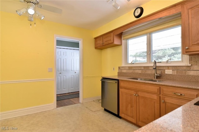 kitchen featuring brown cabinetry, decorative backsplash, light countertops, stainless steel dishwasher, and a sink