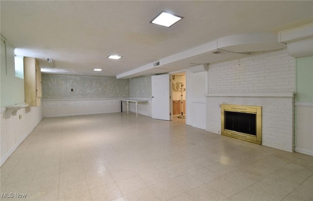 finished basement with light floors and a fireplace