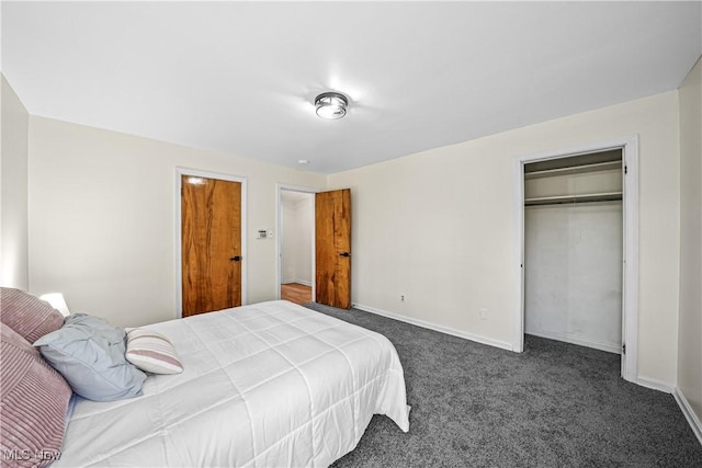 bedroom featuring baseboards, dark colored carpet, and a closet