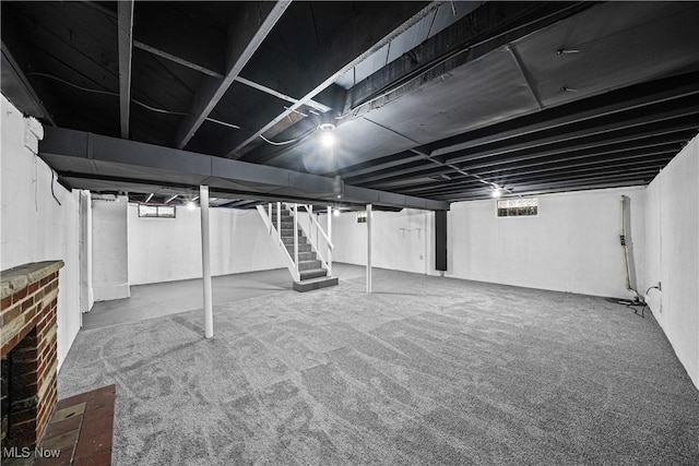 below grade area featuring stairs and carpet flooring