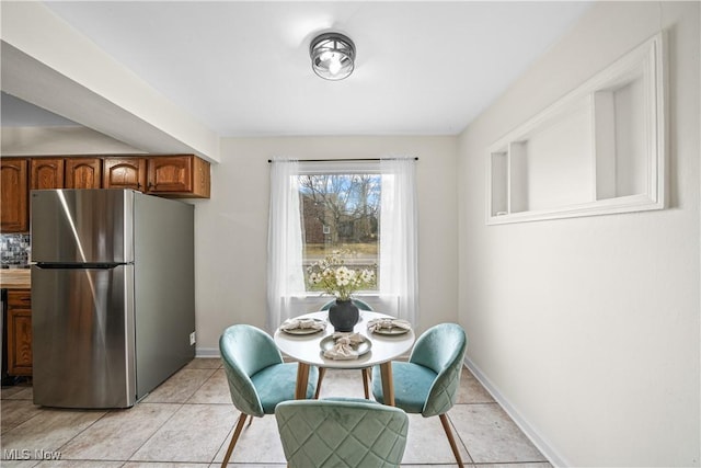 dining room with baseboards and light tile patterned floors