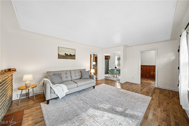 living room with visible vents, baseboards, and wood finished floors