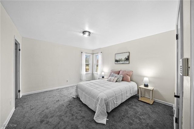 bedroom with baseboards and dark carpet