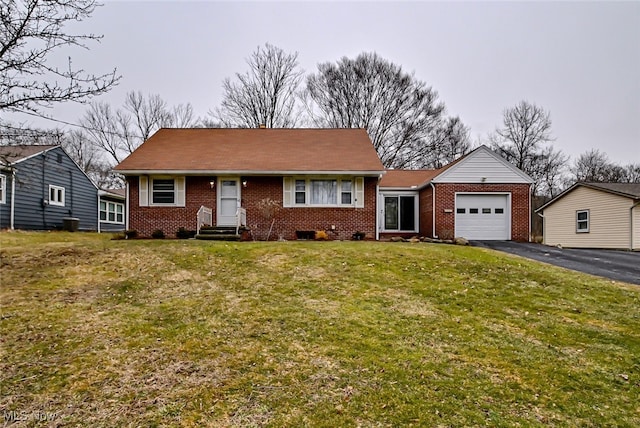 view of front of house with aphalt driveway, a front yard, brick siding, and an attached garage