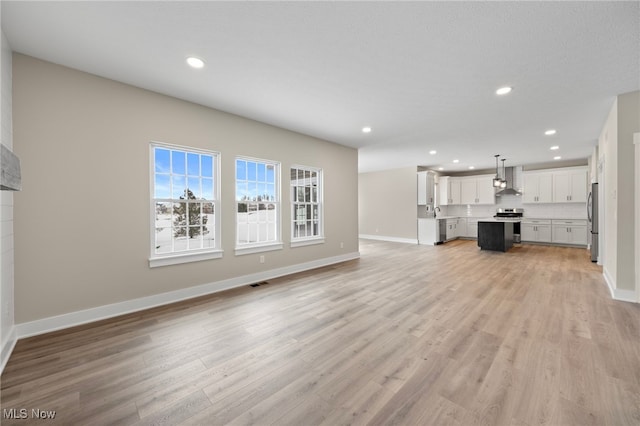 unfurnished living room featuring recessed lighting, visible vents, and light wood finished floors