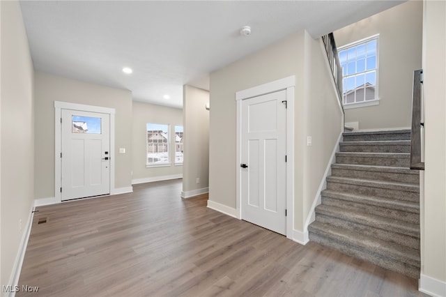 entrance foyer with recessed lighting, visible vents, wood finished floors, baseboards, and stairs