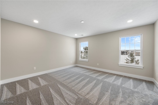 unfurnished room with carpet floors, recessed lighting, visible vents, a textured ceiling, and baseboards