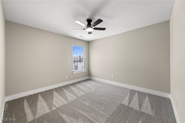 unfurnished room with ceiling fan, a textured ceiling, carpet floors, visible vents, and baseboards