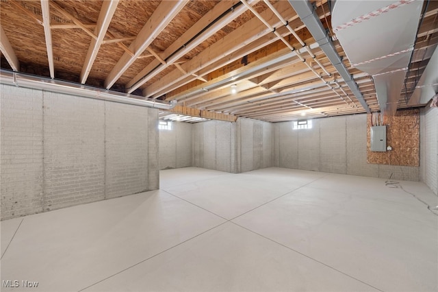 basement with brick wall and electric panel