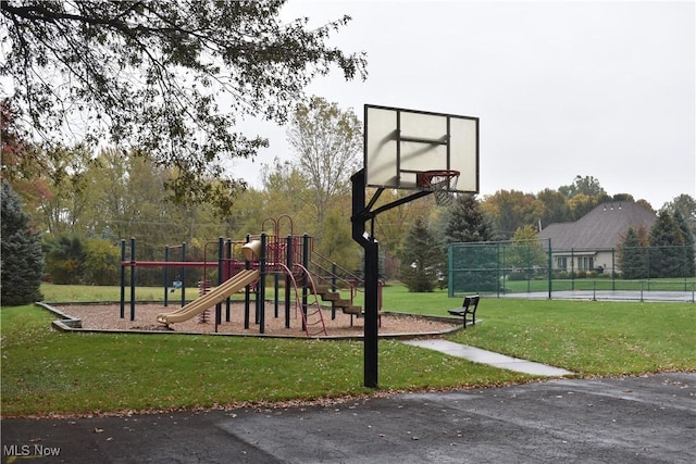 community play area with community basketball court, fence, and a yard