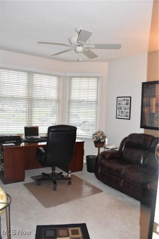 home office featuring a ceiling fan and light carpet