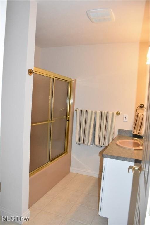bathroom featuring shower / bath combination with glass door, tile patterned flooring, baseboards, and vanity
