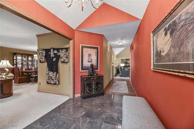 hall with lofted ceiling, an inviting chandelier, and baseboards