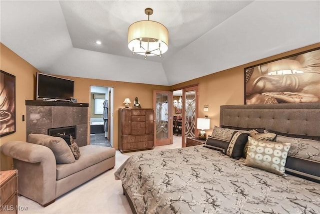 bedroom featuring carpet floors, a fireplace, vaulted ceiling, and ensuite bathroom