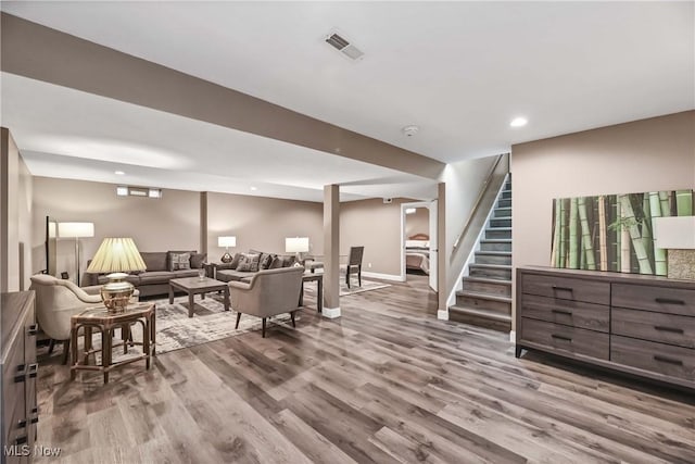 living area featuring recessed lighting, visible vents, wood finished floors, baseboards, and stairs