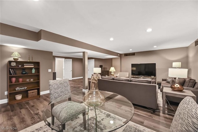 living room with recessed lighting, visible vents, baseboards, and wood finished floors