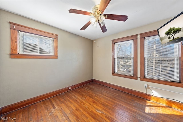 empty room with a ceiling fan, baseboards, and hardwood / wood-style flooring