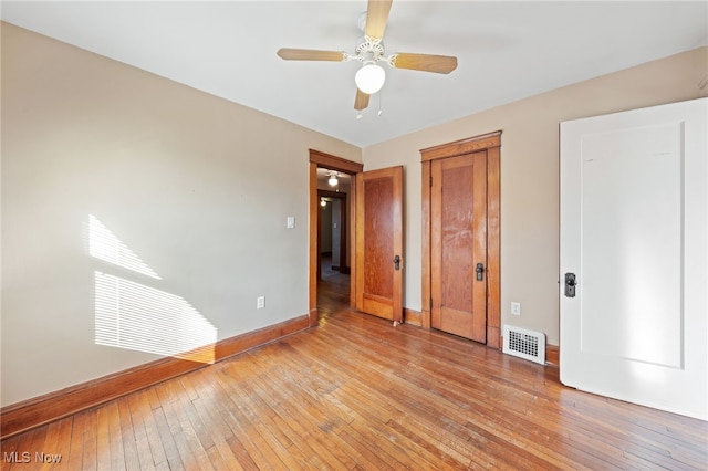 unfurnished bedroom featuring visible vents, baseboards, light wood-style flooring, ceiling fan, and a closet