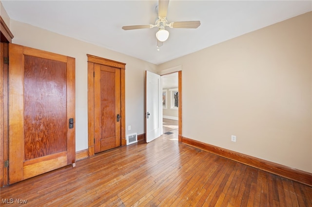 unfurnished bedroom with ceiling fan, light wood-type flooring, visible vents, and baseboards