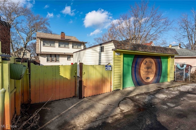 exterior space with a chimney, fence, and a gate