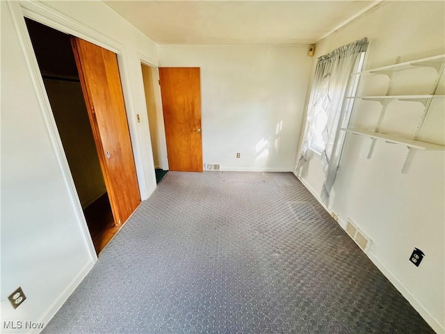 unfurnished bedroom with carpet, visible vents, and baseboards