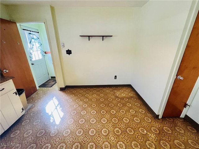 interior space with light tile patterned flooring and baseboards