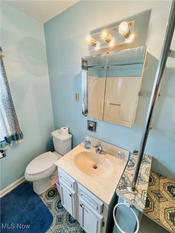 bathroom featuring toilet, baseboards, vanity, and tile patterned floors
