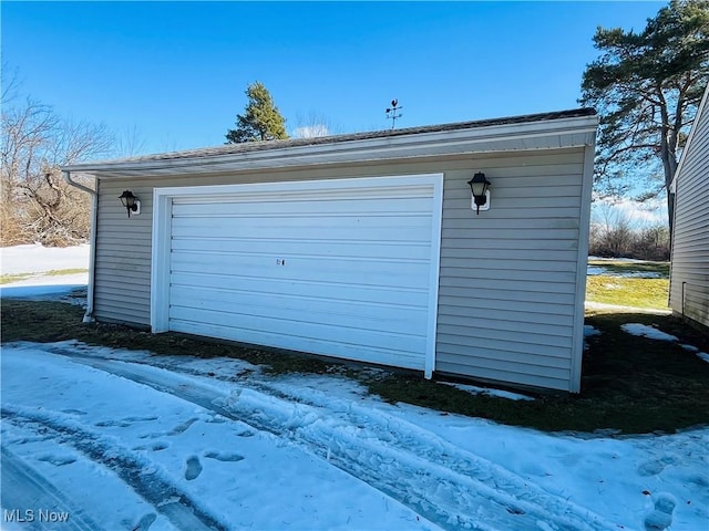 snow covered garage featuring a garage