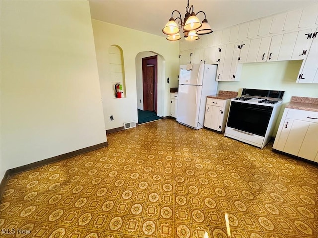 kitchen featuring white appliances, arched walkways, white cabinets, decorative light fixtures, and light countertops