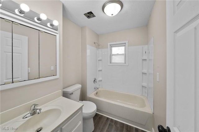 bathroom featuring shower / washtub combination, toilet, a textured ceiling, vanity, and wood finished floors